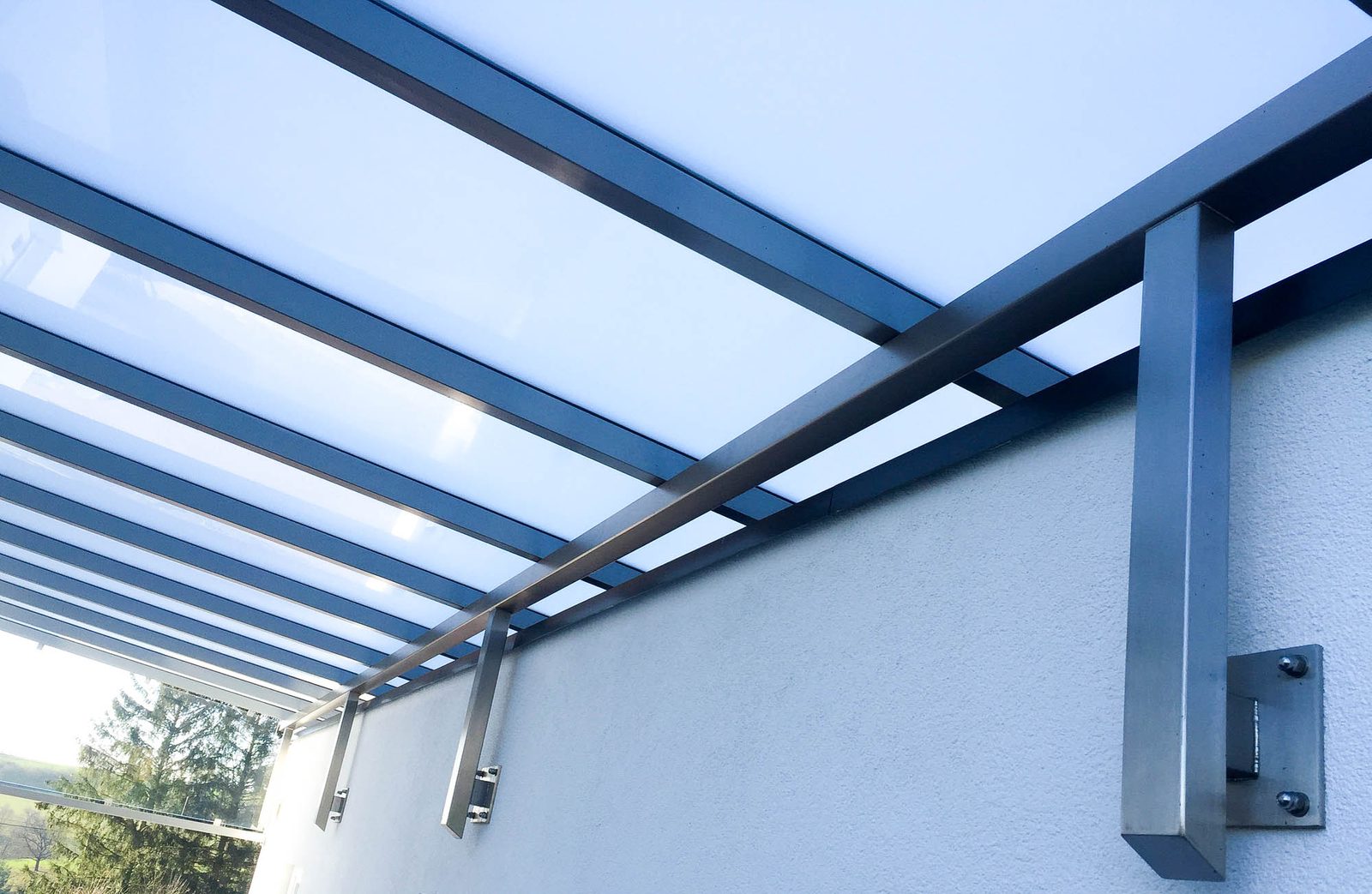 Terrassenüberdachung aus Metall mit Glaseindeckung an einem Wohnhaus